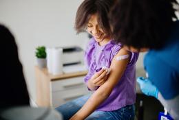 Young girl smiling after taking vaccine shot