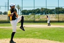 Shot of a young man pitching a ball during a baseball match