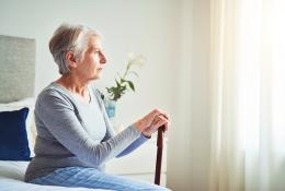 Old woman looking outside of the of the window