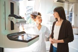 doctor talking with female patient during mammography test in examination room 