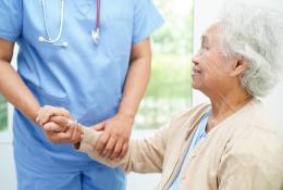 elderly woman holding hands with medical staff
