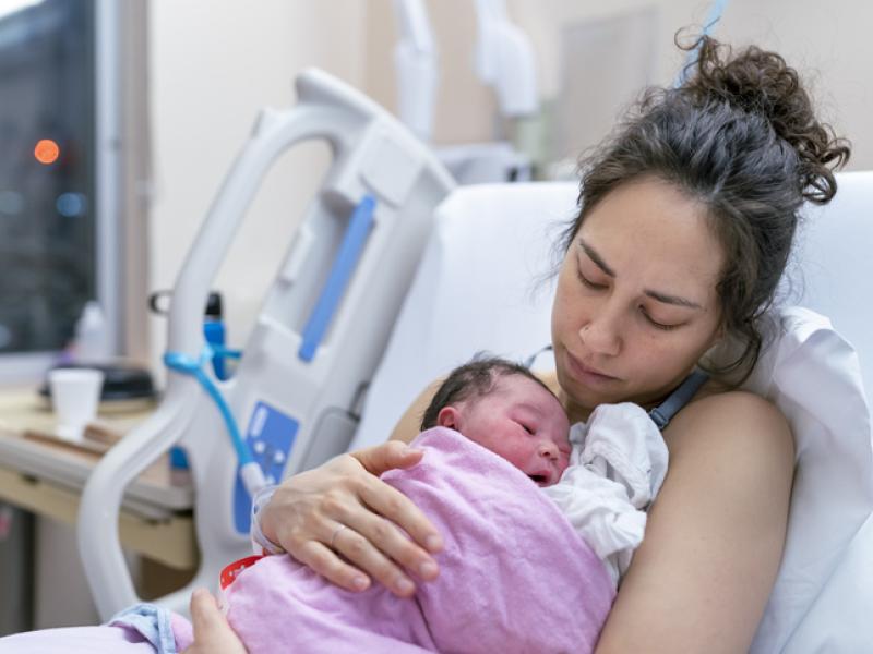 Mother holding newborn baby at hospital