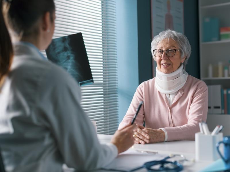 Older Women with Neck Brace meeting her Doctor