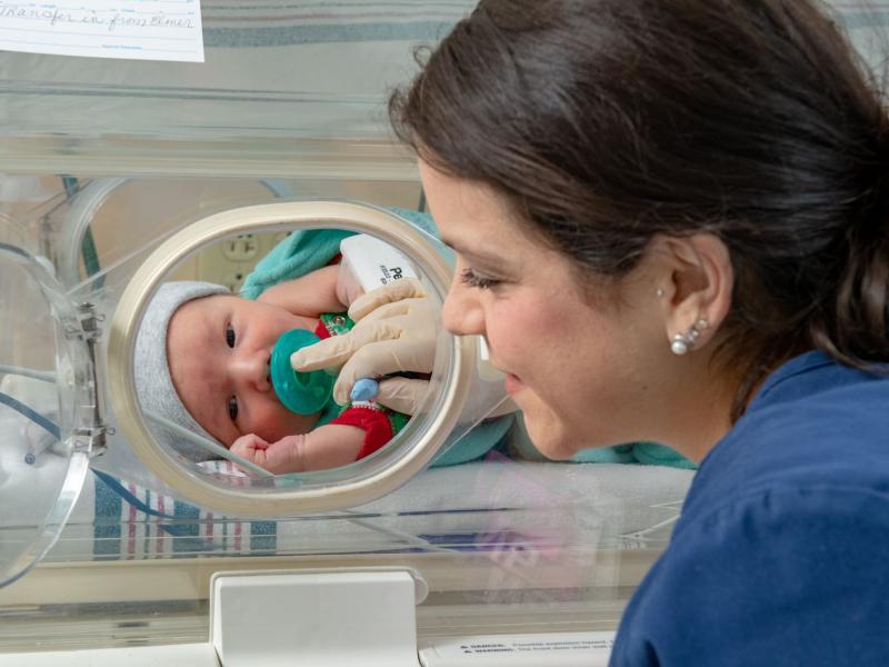 nicu baby in incubator with nurse