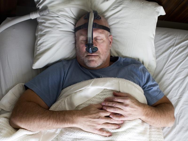 Man with CPAP machine sleeping