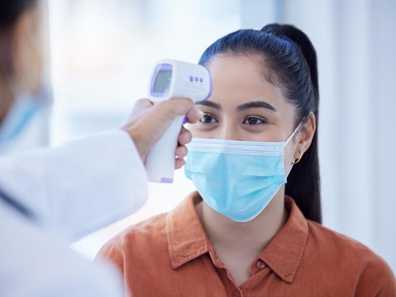 doctor taking temperature on a woman