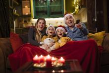 Young family enjoying Christmas movies at home