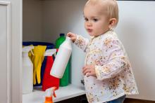 child reaching for an unknown substance in a cabinet