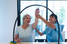 Therapist doing movement therapy with elderly woman patient