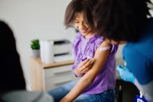 Young girl smiling after taking vaccine shot