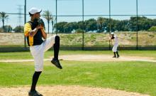 Shot of a young man pitching a ball during a baseball match