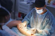 Surgeon performing laparoscopic vascular surgery on a leg