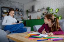 woman work online on mobile with toddler kid at home