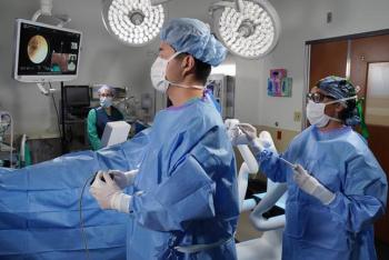 Male and Female Surgeon in blue robes performing surgery