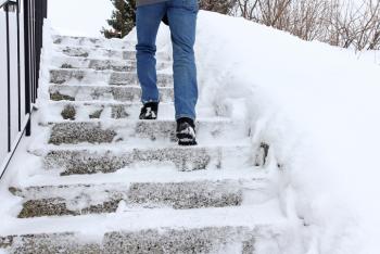 Person walking down icy, snowy steps
