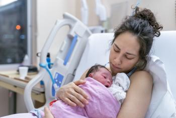 Mother holding newborn baby at hospital