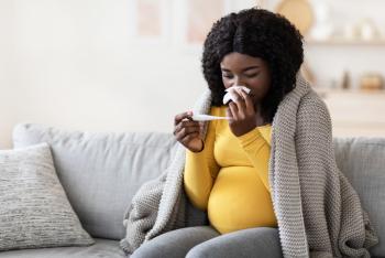 Young pregnant African woman feeling sick with high fever