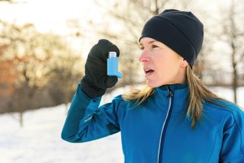 woman outside in snow using inhaler
