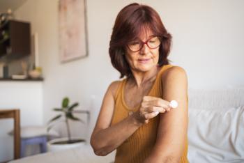 Woman putting bandage on her arm