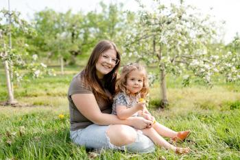 Mom and daughter sitting in apple farm