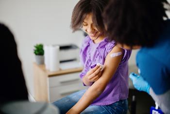 Young girl smiling after taking vaccine shot