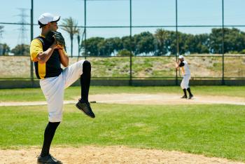 Shot of a young man pitching a ball during a baseball match