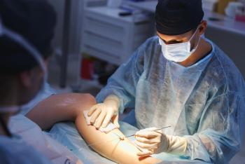 Surgeon performing laparoscopic vascular surgery on a leg