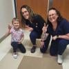 Two nurses posing with Young girl patient